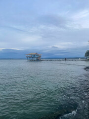Fototapeta premium Wooden stilt house stands above calm Caribbean waters near Bocas del Toro, Panama. Gentle waves, tranquil coast