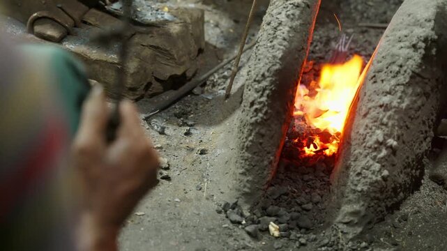 Blazing charcoal fire pit inside a traditional South Asian Bangladeshi village blacksmith forge workshop