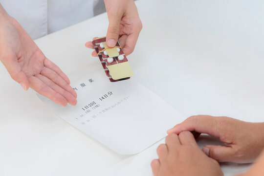 薬剤師が患者にPTPシートの薬を渡す 調剤薬局の服薬指導