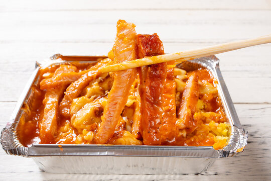 Baked rice with double steak, tomato sauce and melted cheese in disposable aluminum foil container