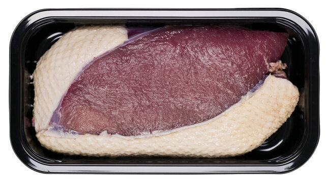 Raw duck breast with skin in black plastic tray