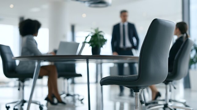 Modern office meeting room with professionals seated around a conference table and one person standing near