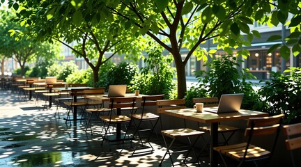Naklejka premium Empty outdoor cafe terrace with tables and laptops under leafy trees. Sunlit dappled shadows fall on wet wooden floor. Relaxing urban park setting with chairs and coffee cups.