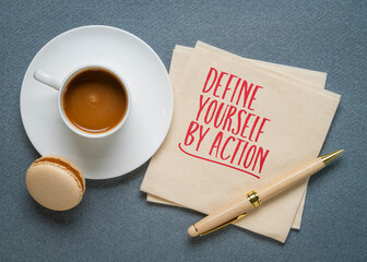 Define Yourself by Action - inspirational handwritten note on a napkin with coffee and pen,...