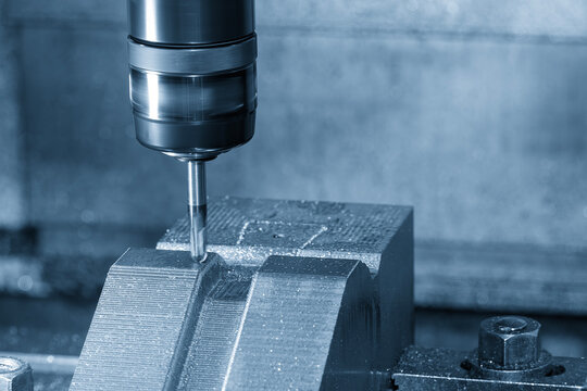 High-precision CNC milling machine performing a finish cut on press die parts with a ball nose end mill tool.