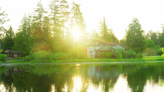 Morning sunburst over calm lake with waterfront houses