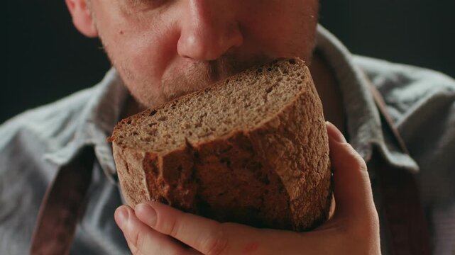 Black rye bread close up, cutting with knife dark brown sliced loaf, borodinsky slavic food, square slices with coriander on white background, baker with tasty healthy fresh bread.