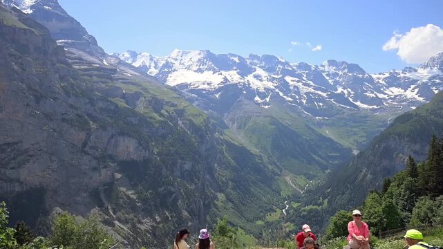 M&uuml;rren, Switzerland - 19.06.2026: Summer hikers pause at an alpine viewpoint above the Lauterbrunnen Valley with snowcapped Bernese Alps in the distance.