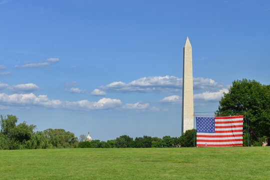 Washington Monument and a large National flag at the National Mall during Independence Day festivities - Washington DC United States