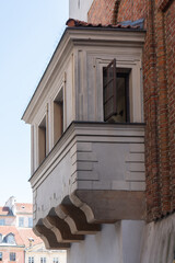 Vintage architectural elements of classical residential house in old town. Renaissance bay window stands on stone corbels near red brick wall under blue sky for architecture blog. © dimetradim