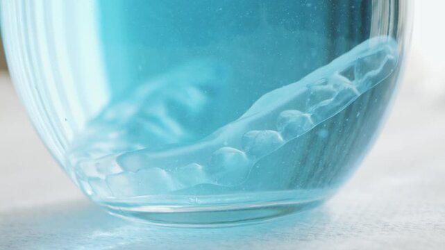  Cleaning clear orthodontic aligners with a tablet cleaner. High quality 4k footage