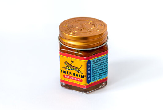 Close up side view of a jar of Tiger Balm ointment isolated on white.