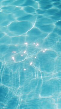 Ripples on the water of the pool, transparent, sparkling, inviting surface of the water in motion, view from above. slow motion and looped video.