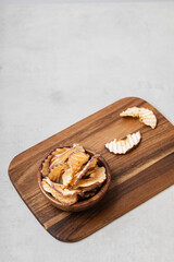 Fototapeta premium Apple chips in a wooden bowl on a light gray background.