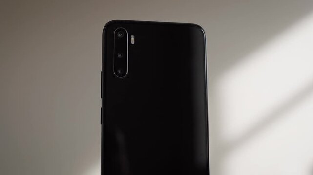 Black smartphone with dual camera on gray background