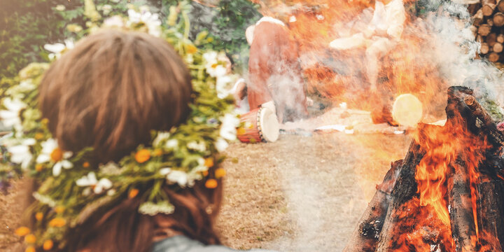 Close-up of a woman wearing a wildflower wreath by the sacred solstice fire.