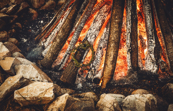 Ceremonial throwing of a wildflower wreath into the sacred solstice fire.