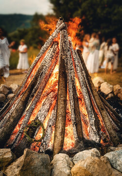 Ceremonial throwing of a wildflower wreath into the sacred solstice fire.