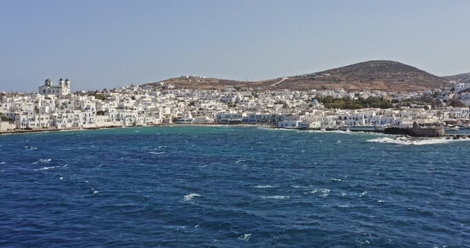 Naousa Paros Greece Aerial v1 low level drone flying toward the touristic village with beautiful white washed buildings, capturing the old venetian castle by the port - September 2021