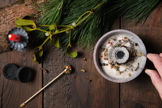 Preparation for an incense ritual - placing a glowing charcoal with tongs, copy space