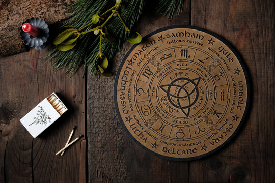 Overhead view of a wooden Wheel of the Year engraved with the eight pagan festivals. Spiritual and wicca concept.