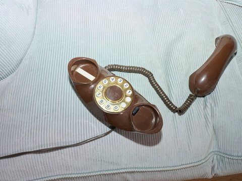 1980's phone on a blue corduroy sofa