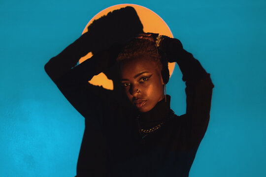 Woman Posing in a Colourful Lighting Setup Indoors