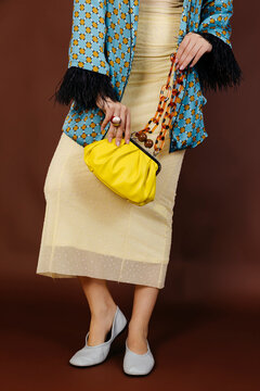Woman holding yellow clutch bag 