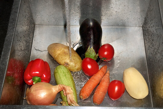 Fresh Vegetables Being Washed in Kitchen Sink Under Running Water