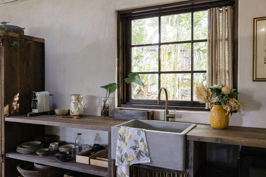 A rustic kitchen with farmhouse sink and open shelving