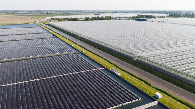 Aerial View of Floating Solar Panels Powering Industrial Greenhouses