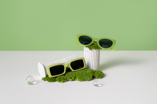 Stylish Green Sunglasses Display with Moss and Minimalist Decor