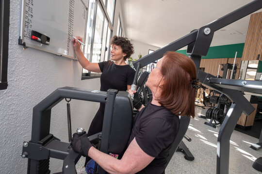 Personal trainer explaining workout plan to client in gym