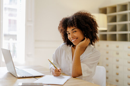 Afro woman smiling while working at office desk