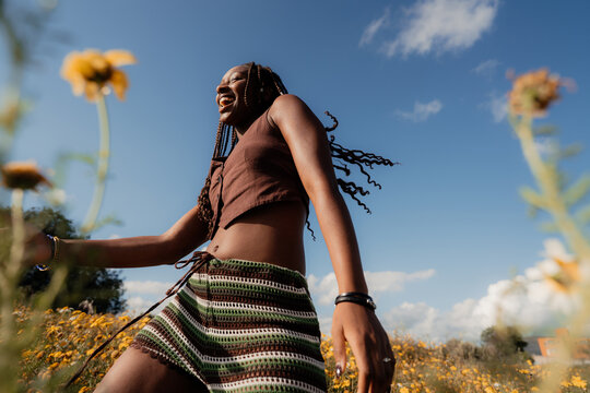 Smiling Woman Dancing in a Field of Flowers