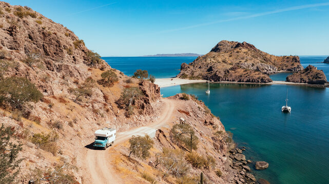 truck camper on coastal cliff road above turquoise bay
