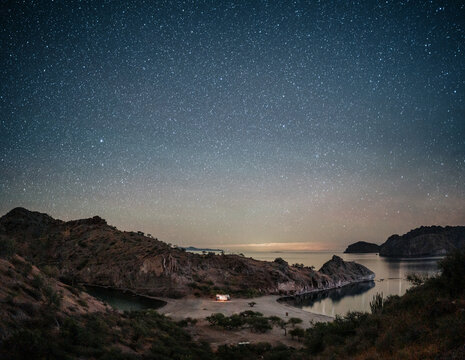 truck camper under starry night sky in desert landscape