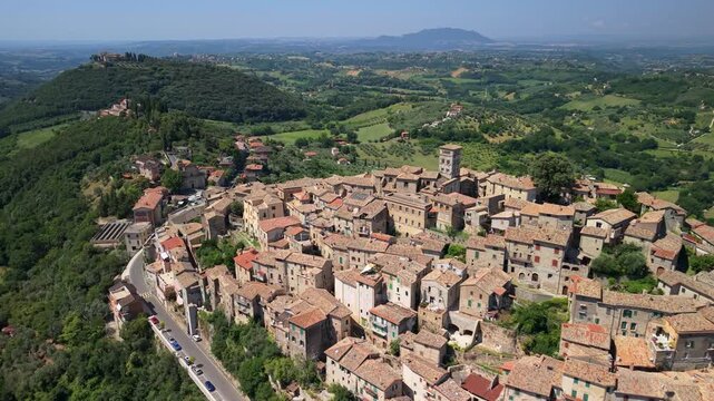 Casperia Italy 4K Drone. Side tracking orbit with camera rotation and pull back reveal of hilltop medieval borgo village in green valley. Cinematic mountain hills aerial b roll video asset
