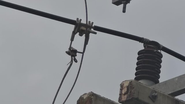 Extreme close up video of a dangerous electrical arc flashing at a hotline clamp connection on a branch line, showing frayed high voltage wire close to breaking.