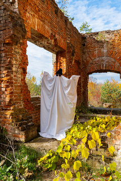 Ghostly figure in autumn ruins with vibrant foliage