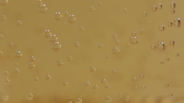 Dark golden-olive liquid surface in extreme macro close-up with fine small bubbles distributed evenly. Bubbles slowly rise and shift across the muted golden-brown surface throughout the shot.