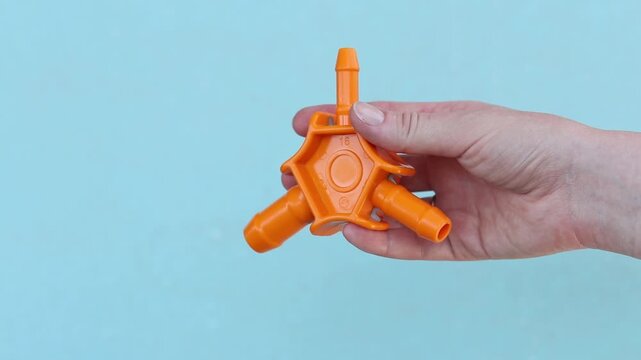 Close-up of a female hand with a plumbing tool for calibrating plastic pipes. Manual calibrator for metal-plastic pipes (16-20-25 mm) with beveling knives. Orange plastic calibrator