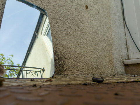 old abandoned building with rusted metal balcony floor and mirror reflecting the beauty of the day