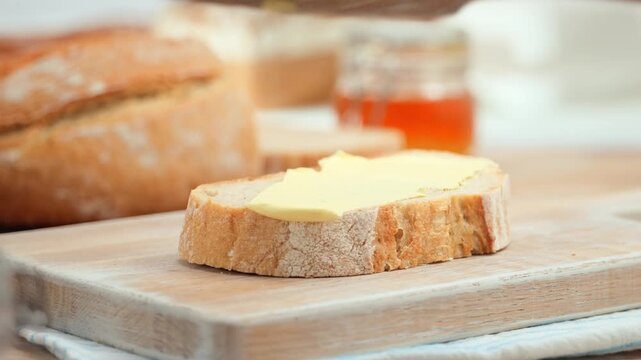 Butter spreading on fresh bread slice, close up homemade breakfast scene, copy space