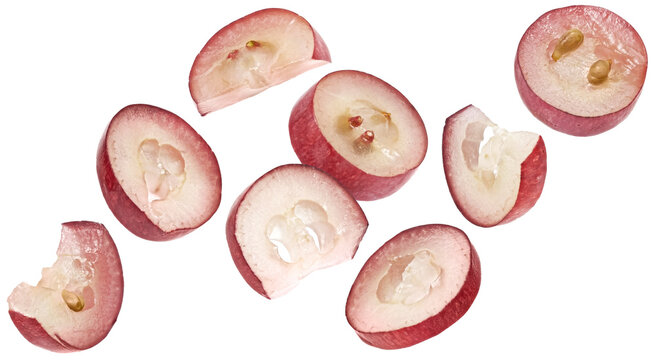 Falling red grape slices isolated on white background