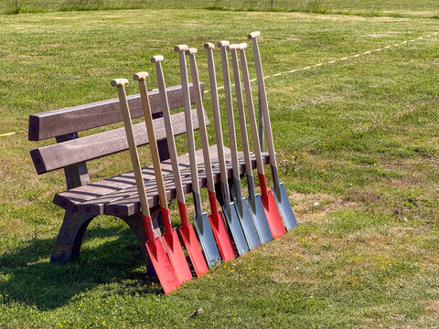 Shovels leaning against a wooden bench in a park