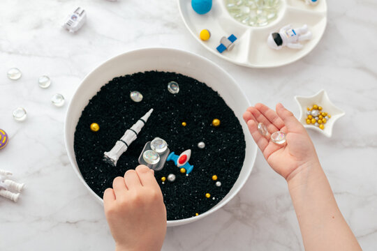 Montessori sensory bin for astronomy fine motor play at home