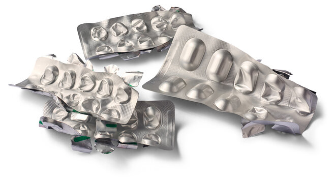 crushed empty pill blister packs isolated white background, used silver aluminum foil medicine packaging waste with shadow