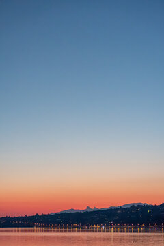 Sunset gradient sky over Lake Geneva and Alpine ridge