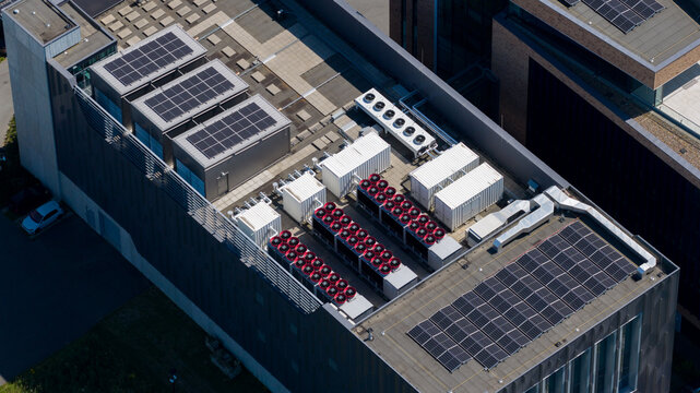 Aerial view of the Interconnect Services BV facility rooftop featuring rows of solar panels and industrial HVAC cooling units in 's-Hertogenbosch, Noord-Brabant, Netherlands.